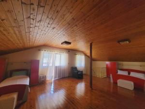 a large room with a wooden ceiling and a bed and couch at Villa Rruga 6 Velipoje in Velipojë +17 photos