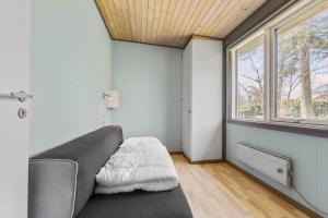 a bedroom with a couch and a window at 84237-Knebel-Skovvej-18 in Skødshoved Strand