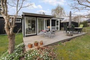 a wooden deck with a table and chairs on it at 84237-Knebel-Skovvej-18 in Skødshoved Strand