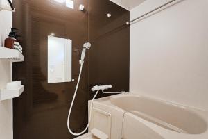 a bathroom with a bath tub and a shower at Tomo House 四谷三丁目 301 in Tokyo +52 photos