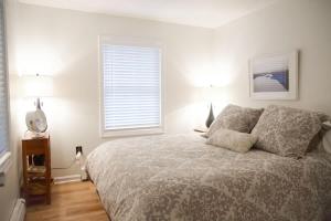 a bedroom with a bed and two lamps and a window at Lincolnville 2BR - Beach Vibes & Backyard BBQ in Lincolnville