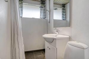a bathroom with a toilet and a sink and a mirror at C11352-Tarm-Hjortevej-8 in Højsand +22 photos