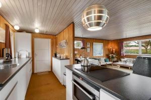 a kitchen with a counter top and a living room at C11714-Hemmet-Traeskoen-8 in Højsand