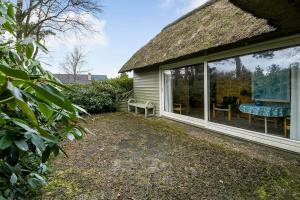 a house with a thatch roof and a patio at C11714-Hemmet-Traeskoen-8 in Højsand