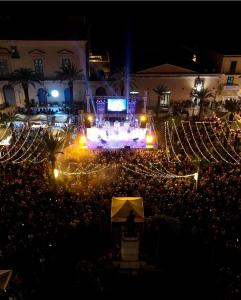 a large crowd of people watching a concert at night at Casa Paola - A due passi dal mare in Pozzallo