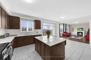 a kitchen with a kitchen island and a living room at Cozy 5 bedrooms & 5 bathrooms House in Tottenham