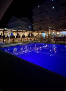 een zwembad met blauw water in de nacht bij Hotel Frida in Himare
