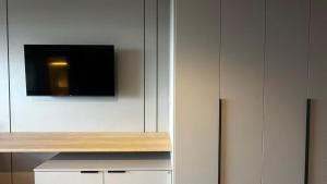 a white cabinet with a television on top of it at Flat Paradise in Natal
