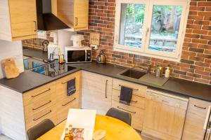 une cuisine avec des armoires en bois et une table en bois dans l'établissement La maison d'Albane Briançon Serre Chevalier Vallée 5 personnes, à Briançon