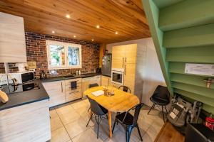 une cuisine avec une table et des chaises en bois dans l'établissement La maison d'Albane Briançon Serre Chevalier Vallée 5 personnes, à Briançon
