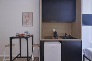 a small kitchen with a counter and a sink at LES BULLES DE MONA - Alcove - Spa - Clim in Lyon