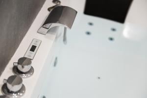 a close up of a bathroom sink with aaucet at LES BULLES DE MONA - Alcove - Spa - Clim in Lyon