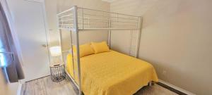 a bedroom with a bunk bed with a yellow bedspread at Bay View Great Deck Pool 2 levels & 3 bedr condo in South Padre Island
