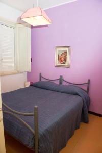 カリーニにあるLomarchi Holiday Homeの紫の壁のベッドルーム1室
