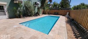 a swimming pool in a yard next to a fence at Large 3 bedr Bay Views Pool Great Deck condo in South Padre Island