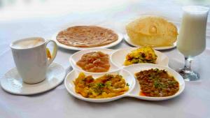 a table with plates of food and a cup of milk at Dream Palace Naran in Naran