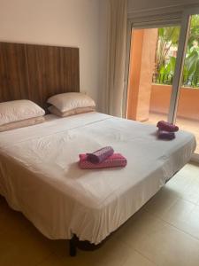 deux pantoufles sont posées sur un lit dans une chambre dans l'établissement Superb 2 Bed Apartment on Mar Menor Golf Resort with Free WIFI, à Los Martínez 22 autres photos