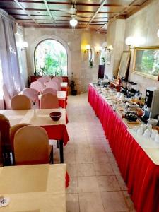 a dining room with tables and chairs with red table runners at Rooms and apartments PALMA B&B in Medulin +39 photos