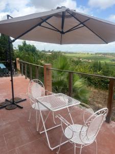a patio with a table and chairs and an umbrella at Casa Perenchiza in Chiva