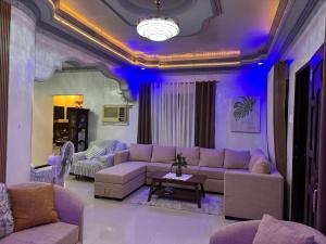 a purple living room with couches and a table at Spacious 3BR Home Comfy Beds Great Location in Kaganjuan