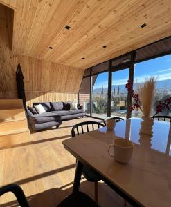 a living room with a table and a couch at Tserovani Velada & Cottages in Mtskheta