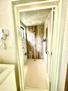 une salle de bain avec une douche à l'italienne à côté d'un lavabo dans l'établissement Happy Inn Kyoto えんの宿, à Kyoto