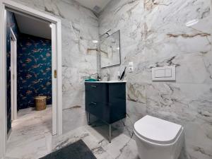 a bathroom with a white toilet and a sink at Mulino Apartments in Borek +6 photos