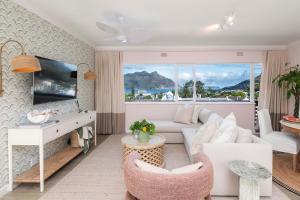 a living room with a white couch and a large window at Chapmans Bay View in Hout Bay