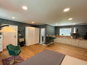 a large kitchen with a green chair and a table at Mulino Apartments in Borek