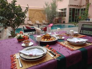 a table with plates of food on a purple table cloth at Riad tania mozaik in Taroudant