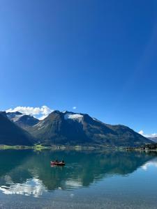 two people in a boat on a lake with mountains at Vollsnes Glamping in Stryn