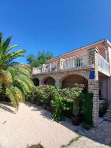 a building with a balcony and a bunch of plants at DosPalmeras in Vir +43 photos