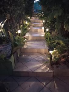 a pathway with lights in a garden at night at Casa Coco Cabana 