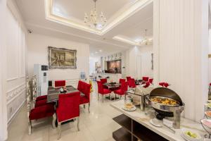 胡志明市A25 Hotel - 255 Lê Thánh Tôn的一间用餐室,配有红色的椅子和餐桌