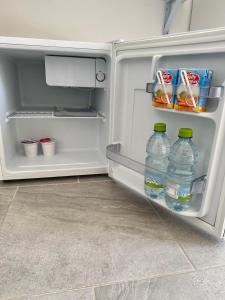 an open refrigerator with two bottles of water and snacks at Garden House in Olbia