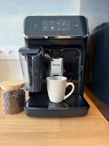 a coffee maker with a cup of coffee on a table at Große Innenstadt-Oase Kiel für Gruppen & Familien in Kiel