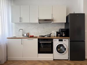 a kitchen with a black refrigerator and a dishwasher at Große Innenstadt-Oase Kiel für Gruppen & Familien in Kiel