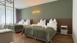 a hotel room with two beds with white pillows at Große Innenstadt-Oase Kiel für Gruppen & Familien in Kiel +9 photos