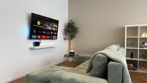 a living room with a couch and a flat screen tv at Große Innenstadt-Oase Kiel für Gruppen & Familien in Kiel