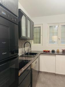a kitchen with a sink and a black appliance at Douceur Paisible in La Ferté-Gaucher