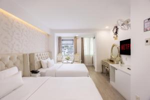 胡志明市A25 Hotel - 255 Lê Thánh Tôn的白色的酒店客房,配有两张床和镜子 更多31张照片