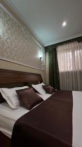 two beds in a hotel room with a window at Sky luxe-hotel Astana in Astana