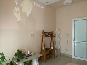 une pièce avec un tableau représentant un homme tenant une tasse dans l'établissement Ở Homestay, à Thôn Trường Giang