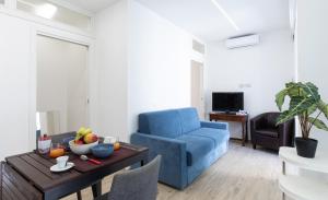 a living room with a blue chair and a table at Appartamenti Antica Posta in Colico