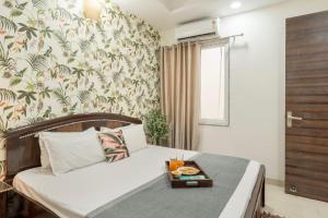 Un dormitorio con una cama con una bandeja de comida encima. en SaffronStays Kridha Niwas, en Vrindāvan