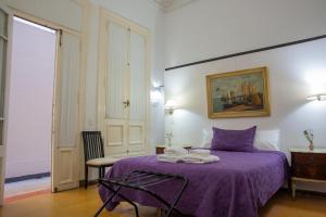a bedroom with a purple bed with towels on it at Lezama Suites in Buenos Aires