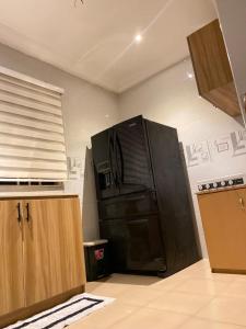 a kitchen with a black refrigerator in a room at PacificAirbnb in Abrekuma