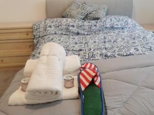 a bed with towels and a pair of ties on it at Newly amazing refurbished two bedroom apartment in Harrow on the Hill