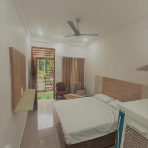 a bedroom with a bed and a ceiling fan at Prem Home Stay in Rishīkesh +17 photos