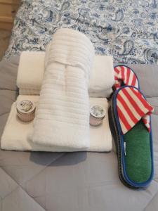 a bed with two towels and two clocks on it at Newly amazing refurbished two bedroom apartment in Harrow on the Hill